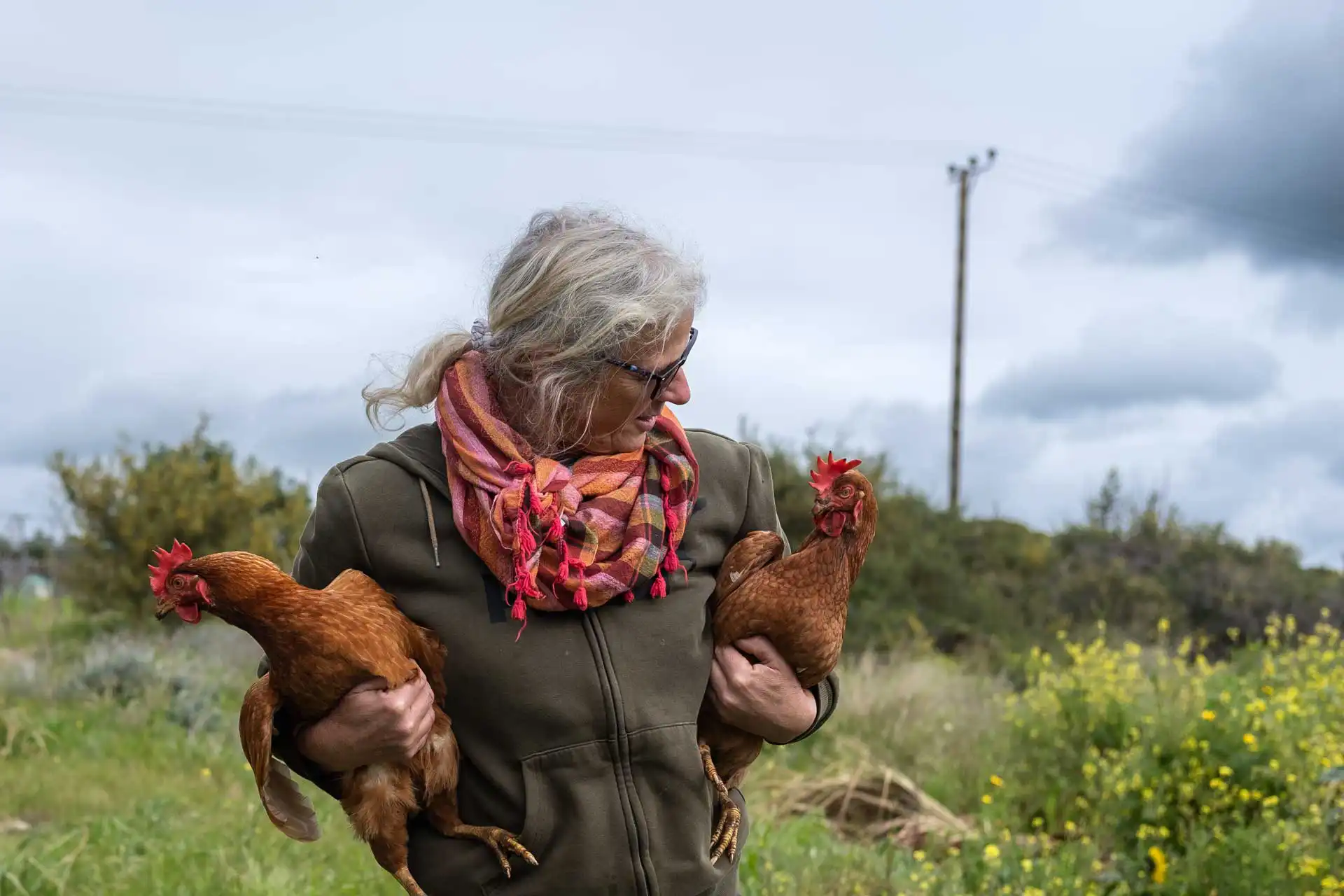Paphos Green Goddess is holding two chicken in her arms